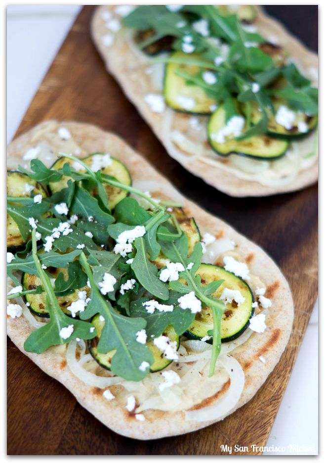 zucchini flatbread with onions, hummus, arugula