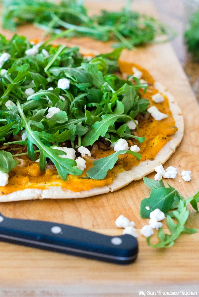 butternut squash pizza with caramelized onions, arugula and goat cheese